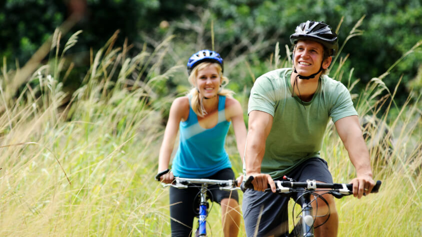 A man and a woman riding their bicycle