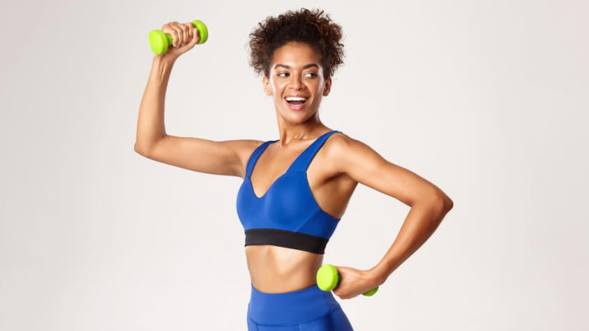 A woman holding two dumbbells