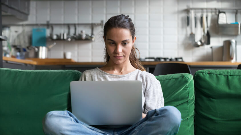 Girl sitting on a couch with a laptop