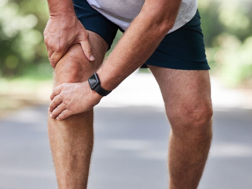 A man holds his right knee