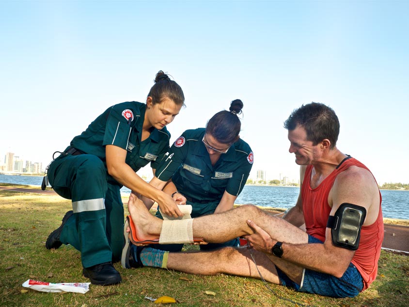 Two paramedics treat a man