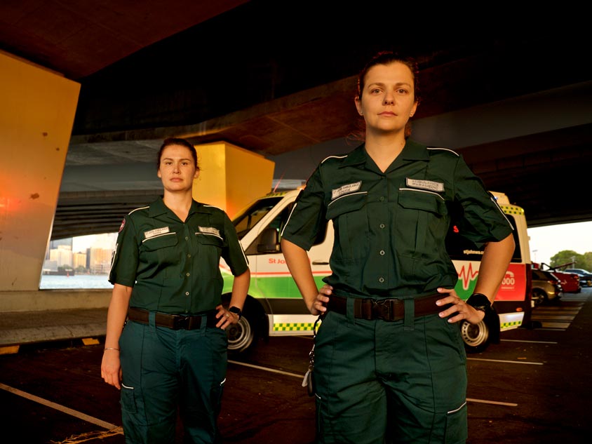 Two paramedics standing in front of an ambulance